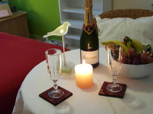 uma garrafa de vinho e dois copos numa mesa com uma vela em EL TULIPAN Relax a 100m del Mar em Candelaria