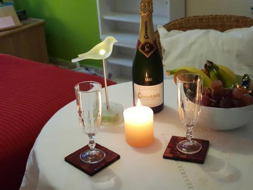 a bottle of wine and two glasses on a table with a candle at THE POPPIES Guest House - 100m Ocean - Private Spaces in Candelaria