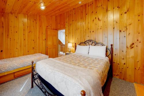 1 dormitorio con 1 cama en una pared de madera en Palisades Pines, en Paris