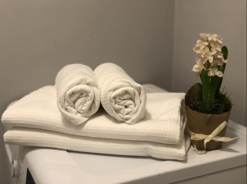 a pile of towels on a table with a vase of flowers at Apartament Centrum Zamoyskiego in Zakopane