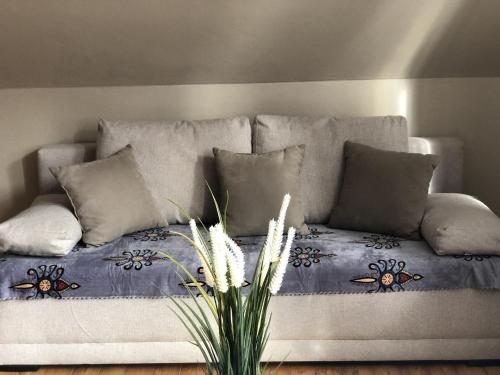 a couch with a blue blanket and pillows at Apartament Centrum Zamoyskiego in Zakopane