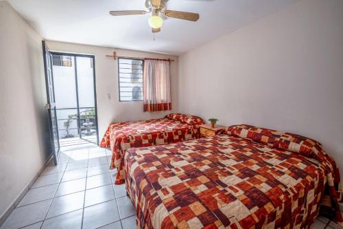 1 dormitorio con 2 camas y ventilador de techo en Hotel Meson de Isabel, en Querétaro