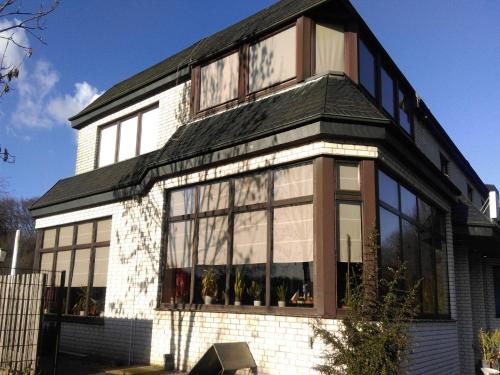 une maison avec un toit noir et des fenêtres dans l'établissement Landhaus Sundern, à Tecklembourg