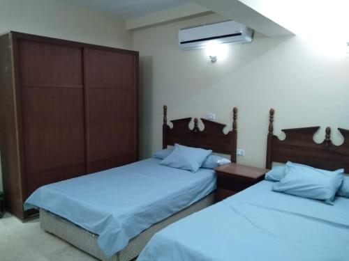 Apartment في الغردقة: غرفة نوم بسريرين مع وسائد زرقاء