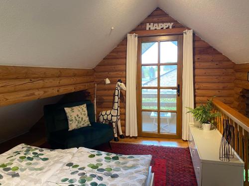 een slaapkamer met een bed en een vrolijk bord op het raam bij Eifel-Lounge BLOCKHAUS in Weilerswist