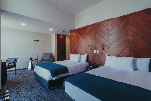 Atix Hotel في لاباز: غرفة فندقية بسريرين وكرسي