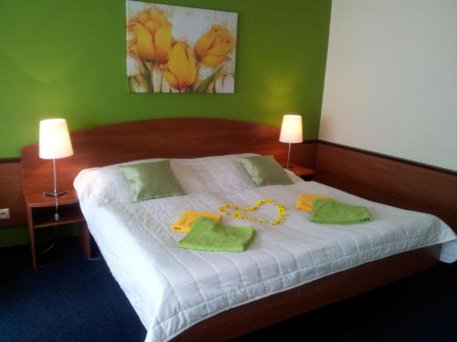 a bedroom with a white bed with green walls at Hotel Centrum Harrachov in Harrachov