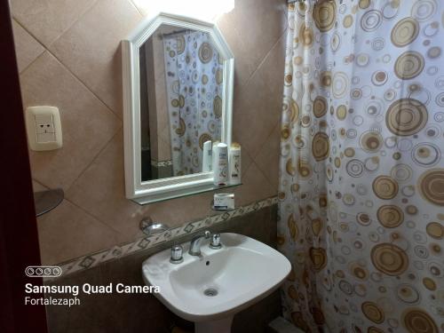 W łazience znajduje się umywalka i lustro. w obiekcie La Villarense w BuenosAires
