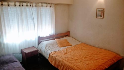 ein kleines Schlafzimmer mit einem Bett und einem Fenster in der Unterkunft Vila Gesell, zona centro y playa in Villa Gesell