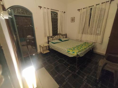 a small bedroom with a bed and a window at Casamore in Vagator