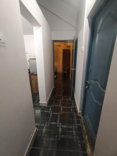 a hallway with a tile floor and a blue door at Casamore in Vagator