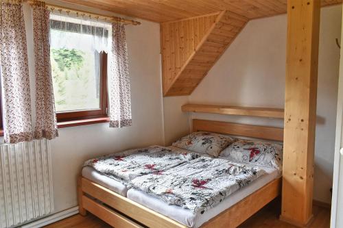 ein Schlafzimmer mit einem Bett in einem Haus in der Unterkunft Chalupa Orlička in Výprachtice