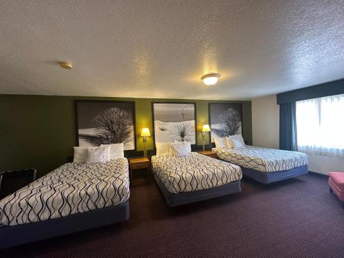 ein Hotelzimmer mit 2 Betten und einem Fenster in der Unterkunft Simple Rewards Inn in Ruidoso