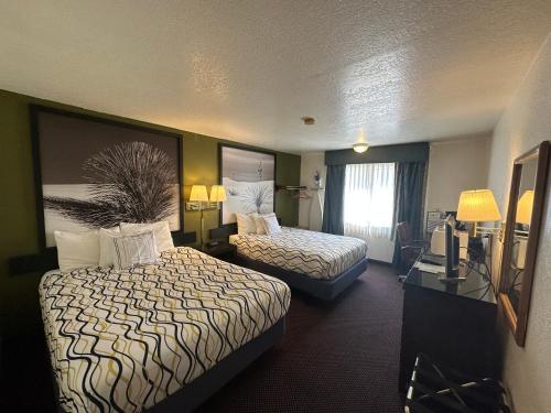 a hotel room with two beds and a window at Simple Rewards Inn in Ruidoso