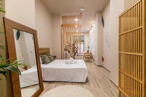 een slaapkamer met een bed en een spiegel bij Art Lofts Gardens in Valencia