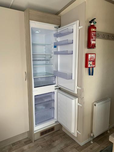 an empty refrigerator with its door open in a room at Beautiful Cornish Getaway, Static Caravan - Newperran Holiday Resort in Cubert