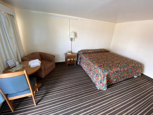 a hotel room with a bed and a chair and a desk at Western inn in Tulsa