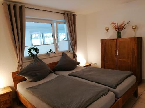 1 dormitorio con 2 camas con almohadas y ventana en Froschkönig mit Teichblick, en Trendelburg