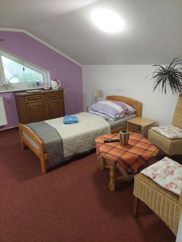 a bedroom with two beds and a table and chairs at Penzion SLUNCE in Česká Lípa