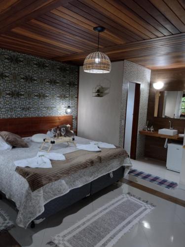 a bedroom with a large bed in a room at Chale Disco de Arado in Visconde De Maua