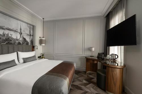 a bedroom with a bed and a desk with a television at Livro Hotel in Istanbul