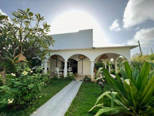 a white house with a dog standing in front of it at Ginger Villa Somone in Somone