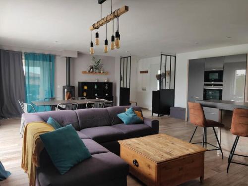 un salon avec un canapé violet et une table dans l'établissement La Montaurousienne - Maison néo-provençale dans le Pays de Fayence, à Montauroux