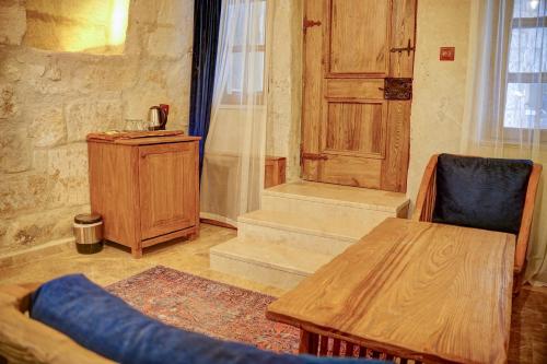 a room with a wooden table and a wooden door at Calypso Cave Suites in Urgup