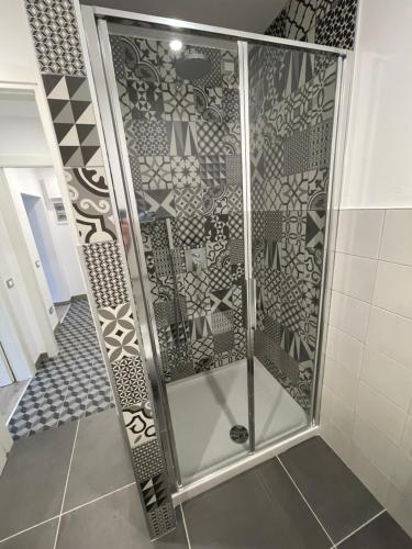 prysznic ze szklanymi drzwiami i podłogą wyłożoną kafelkami w obiekcie Smart Silver Apartment Central w Bergamo