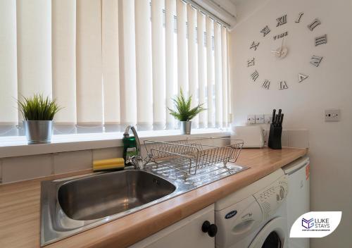 a kitchen with a sink and a clock on the wall at Luke Stays - Ashdown in Durham