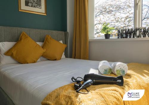 uma cama com almofadas amarelas e um roupão preto em Luke Stays - Ashdown em Durham