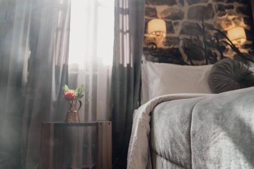 a bedroom with a bed and a window with curtains at 4 Seasons Premium Chalet & Massage Treatments in Palaios Agios Athanasios