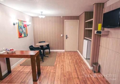 a room with a desk and a table and a television at Complexo Eco Cataratas Resort by SJ in Foz do Iguaçu
