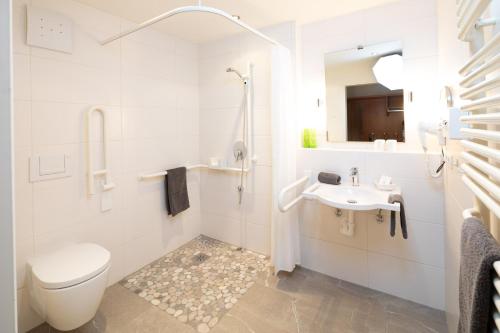 a white bathroom with a toilet and a sink at Familien- und Wellnesshotel "Viktoria" in Oberstdorf