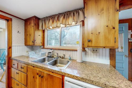 eine Küche mit Holzschränken und einem Waschbecken in der Unterkunft Owls Nest in Owls Head