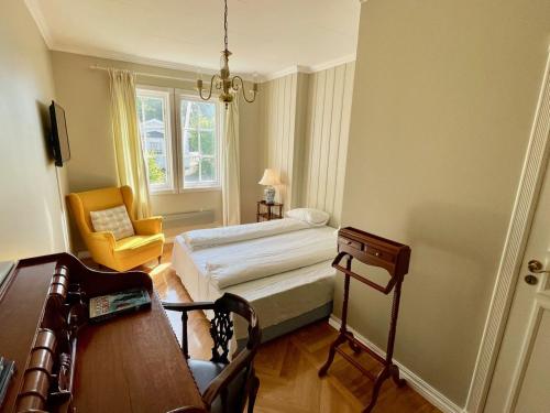 a bedroom with a bed and a chair and a table at Langesund Bad in Langesund