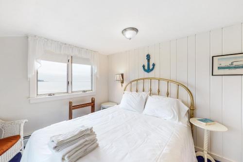 a bedroom with a white bed and a window at Owls Nest in Owls Head