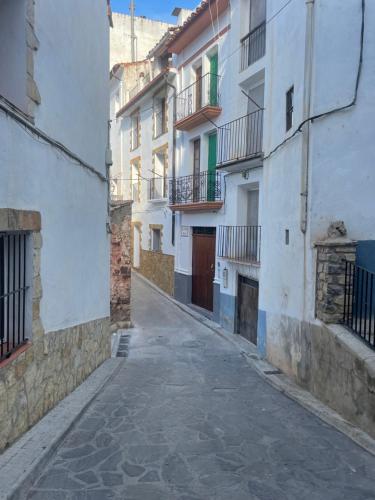 alejka pomiędzy dwoma białymi budynkami z balkonami w obiekcie CASA RURAL SAN JULIAN w mieście Villahermosa del Río