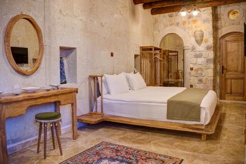 a bedroom with a bed and a mirror and a table at Calypso Cave Suites in Ürgüp