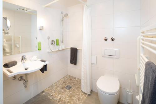 a white bathroom with a toilet and a sink at Familien- und Wellnesshotel "Viktoria" in Oberstdorf