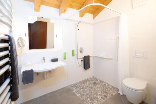 a white bathroom with a sink and a toilet at Familien- und Wellnesshotel "Viktoria" in Oberstdorf