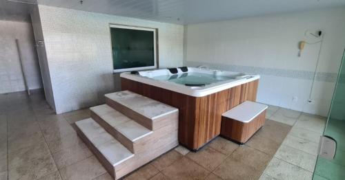 baño grande con bañera y TV en Maravilhoso flat em Pontal Beach Resort Recreio RJ, en Río de Janeiro