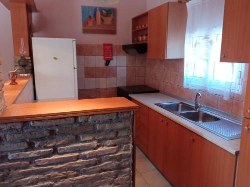 a kitchen with a sink and a brick wall at Sminos Farm House E4 path, Γυθειο 