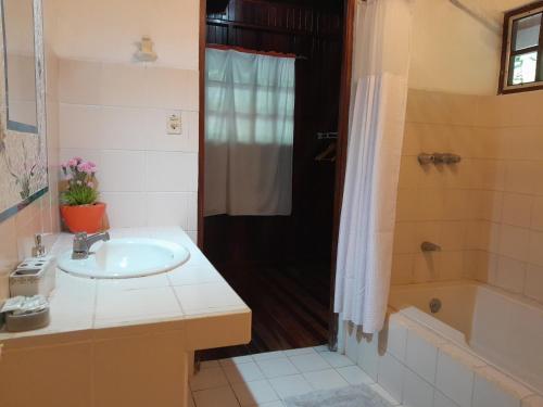 uma casa de banho com um lavatório, um chuveiro e uma banheira em Casas Guaney em Manuel Antonio