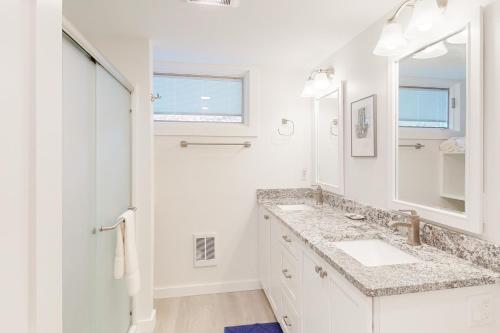 a white bathroom with a sink and a mirror at Sandpiper 1 in Glen Arbor