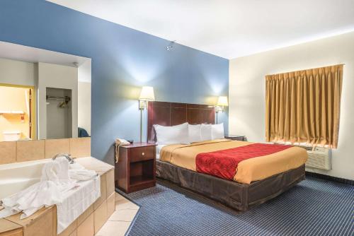 a hotel room with a bed and a bath tub at Econo Lodge Inn & Suites Pritchard Road North Little Rock in North Little Rock