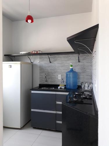 cocina con fogones y nevera blanca en Centrinho Canasvieiras 202 2 andar, en Florianópolis