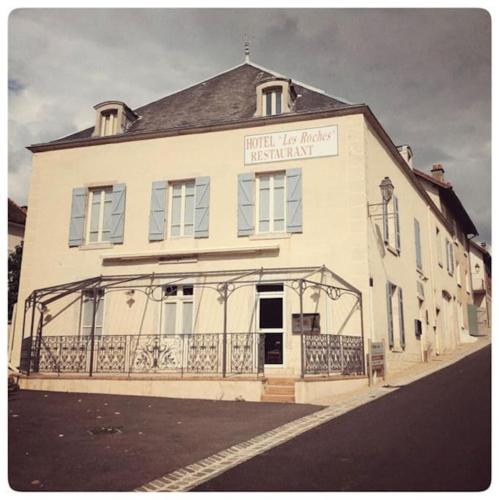 a large white building with a sign on it at Gîte Les Roches : maison de caractère pour 15 personnes in Saint-Romain
