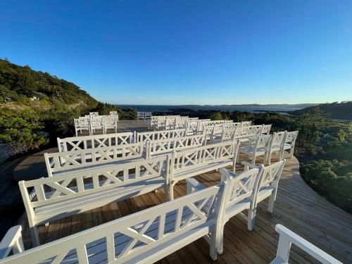 a row of white benches on a wooden deck at Langesund Bad in Langesund