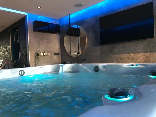 łazienka z wanną wypełnioną wodą w obiekcie L’ODYSSÉE SPA w mieście Seclin